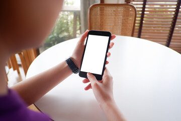 Cropped shot view of woman’s Hands hold the smartphone with blank copy space screen for your information content or text message on the gray granite at the modern place.