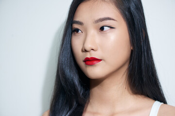 Closeup portrait of a young beautiful attractive asian woman feeling happily over a white background