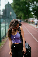 Fototapeta na wymiar Young sporty woman listening music on running track. Beautiful woman in sportswear. 