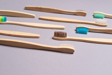 Set of bamboo toothbrushes. Different color. Ecology wood tooth brush group. Grey background. Natural oral hygiene. Dental zero waste protection