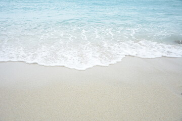 Fototapeta na wymiar Soft wave of turquoise sea water on the sandy beach