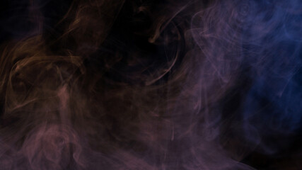 Conceptual image of multi-colored smoke isolated on dark black background and wooden table.