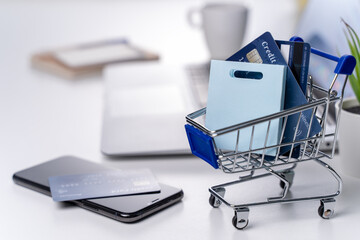 Office online paying, stay home shopping, electronic payment with credit card concept, laptop on white table background with shop cart, close up.