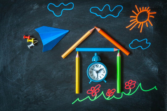 Back to school background with school made from pencils, alarm clock, paper plane, and chalk drawing