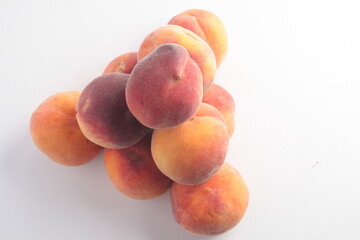 a pyramid of peaches with a triangular base is laid out on a light background