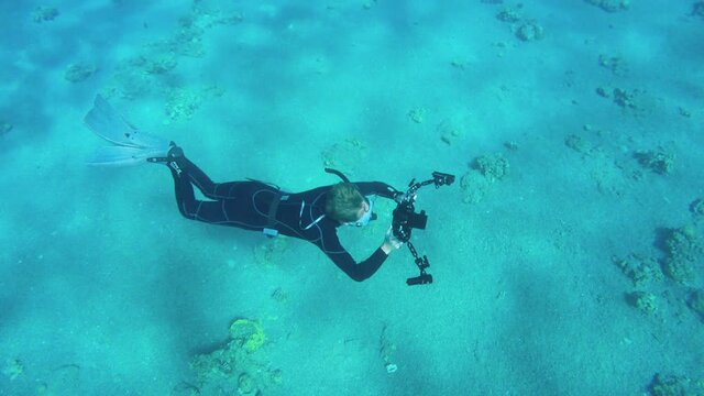 a diving photographer in clear blue sea