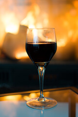 Glass of wine in front of a hot fireplace.