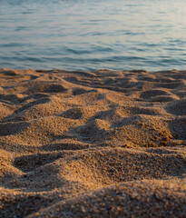 Close up of sandy beach with turquoise water.  Copy space. Warm and cold tones