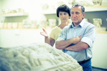mature couple turists examines basrelief of tomb  in historical museum