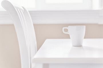 White coffee cup on the clear white table side view