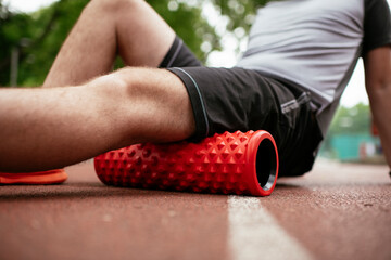 Man foam rolling. Athlete stretches using a foam roller	