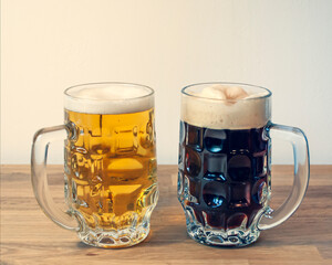 International Beer Day 2nd August. Two types of beer in vintage soviet beer glass: light and dark, on a wooden table. October fest theme. Holidays at home during isolation time.