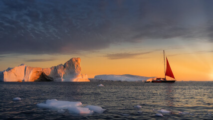 Fototapeta na wymiar Greenland Ilulissat glaciers at ocean with red sailing boat