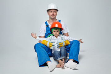 adult man with a young son in construction helmets. the concept of the construction