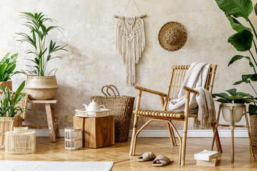 Stylish and floral composition of living room interior with rattan armchair, a lot of tropical...