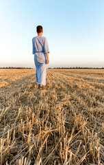 woman farmer walks through a mown wheat field in Ukraine