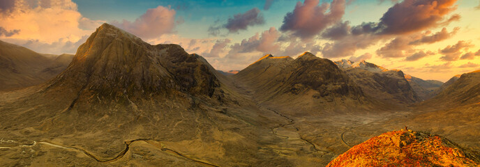 sunrise View of the valley and mountains with tourist on hill at Glencoe, Highlands, Scotland, Great Britain.
