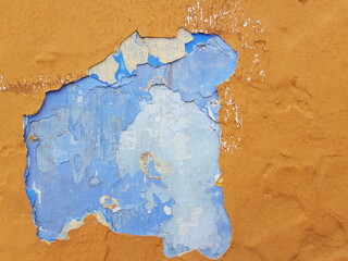 Damaged wall texture. Yellow and blue paint peeling off the wall.
