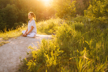 Full peace and tranquillity meditative young woman meditating sitting in lotus position with closed...