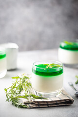 Fototapeta na wymiar Dessert Panna Cotta with green tarragon sauce and fresh tarragon on white background