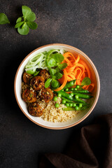 Vegan Buddha bowl with vegetable balls, quinoa, carrots, cucumber and peas. Vegetarian healthy balance nutrition