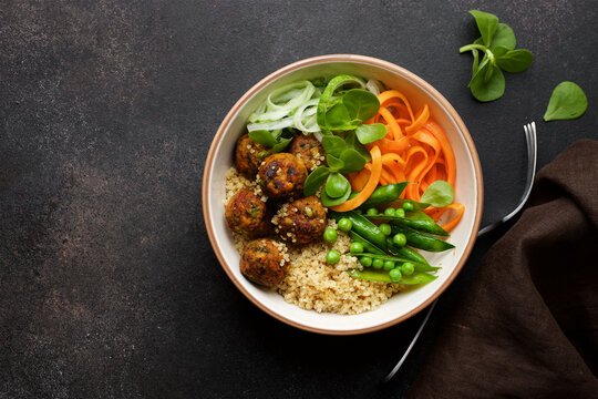 Vegan Buddha bowl with vegetable balls, quinoa, carrots, cucumber and peas. Vegetarian healthy balance nutrition