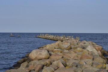 Stone breakwater in the blue sea and blue sky