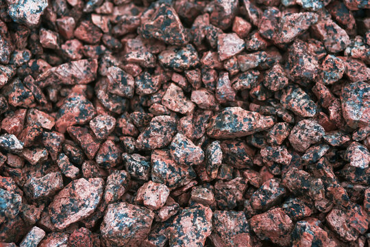 Abstract image of a pile of rubble made of pink granite. Material for construction.