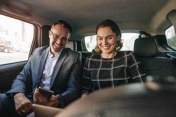 Business people working in backseat of car