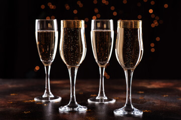 selective focus of glasses full of champagne against christmas lights.