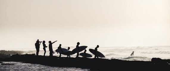 group of people having fun together entering to the water at the beach to surfing - surfers enjoying summer and ocean - vacations and holiday or journey concept - obrazy, fototapety, plakaty