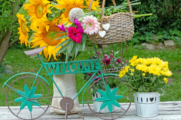 Fahrrad mit Schriftzug Welcome mit Blumenstrauss und Sonnenblumen