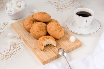 homemade biscuit cookies on a bamboo board, a cup of coffee, refined sugar - still life in light colors
