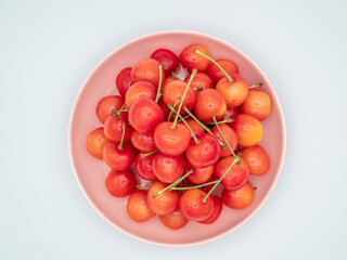 ピンクの皿に山盛りのサクランボ