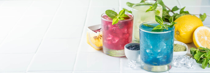Selection of matcha lemonades - green, blue, red on white background, copy space