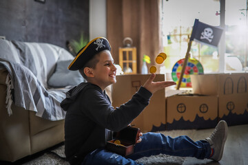 The little boy imagining the pirate excitedly throws and bites the gold coins