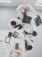 Medical team sitting and discussing at table, top view