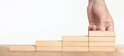 Hand arranging wood block stacking as step stair, Business concept growth success process