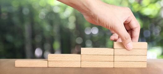 Hand arranging wood block stacking as step stair, Business concept growth success process