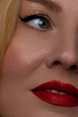 Naklejka premium Beautiful portrait of a female face. A beautiful mature model with perfect clear skin, red lips, long eyelashes and arrows. Blond long hair youth and skin care concept. anti-aging effect