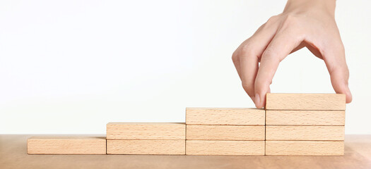 Hand arranging wood block stacking as step stair, Business concept growth success process