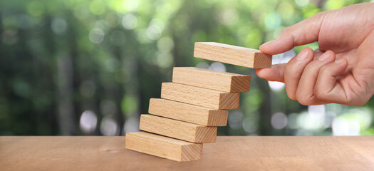 Hand arranging wood block stacking as step stair, Business concept growth success process
