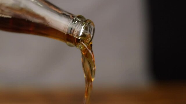 serving cola drink from glass bottle close up slow motion