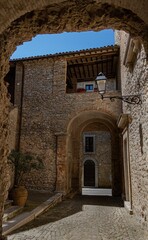 old stone village, Civitella del lago, Umbria _ pretty foreshortening of an ancient alley made of san pietrini and embellished with arches. A lamppost on a wall of ancient bricks faces the entrance 