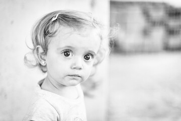 Retrato de niña rubia de ojos grandes mirando hacia la cámara en blanco y negro