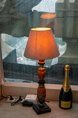 still life with a lamp of orange light on the sill
