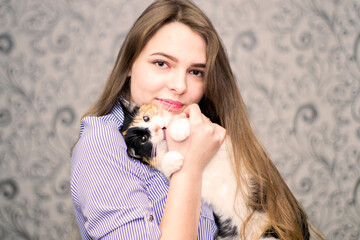 Obraz premium Portrait of a girl with a cat in her hands.