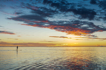 paddle board and sunset over tropical beach