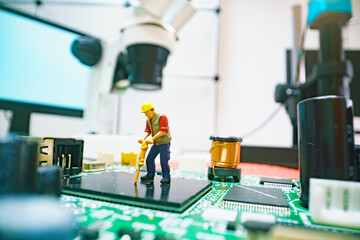 Miniature repair man on mainboard, Miniature figure of worker team try to repair cpu on mainboard.