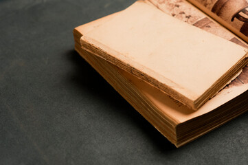 old book with smooth cover on top of big book, on gray background. top view